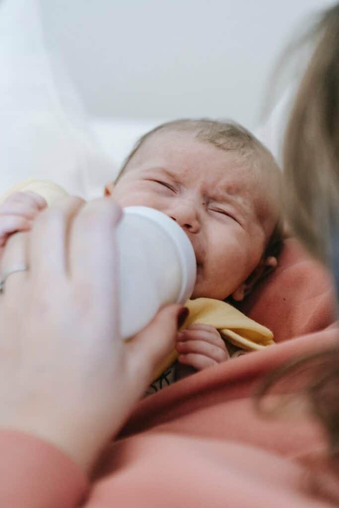 Baby getting fed a bottle