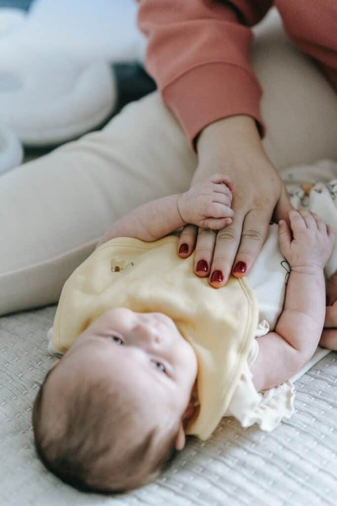 Gas and constipation in babies Woman rubbing baby's belly