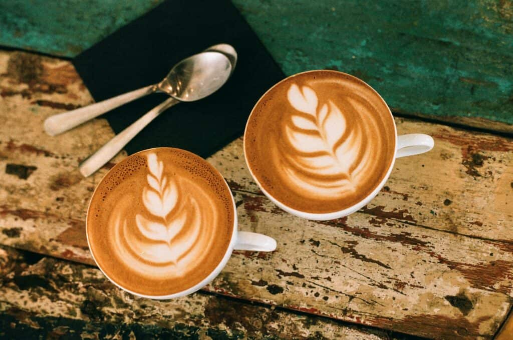 Two flat white coffees on wooden table