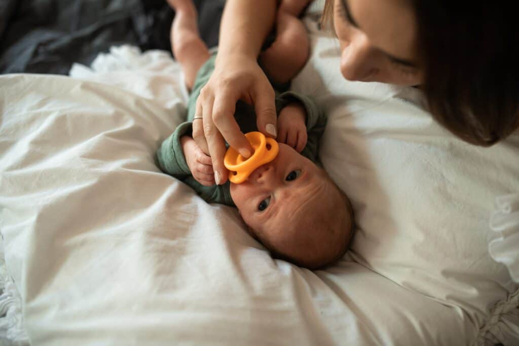 Baby laying on back with pacifier