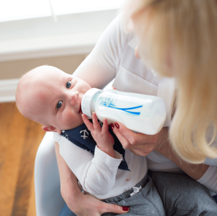 Woman bottle feeding baby