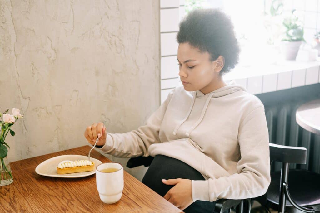 Pregnant woman eating a pastry