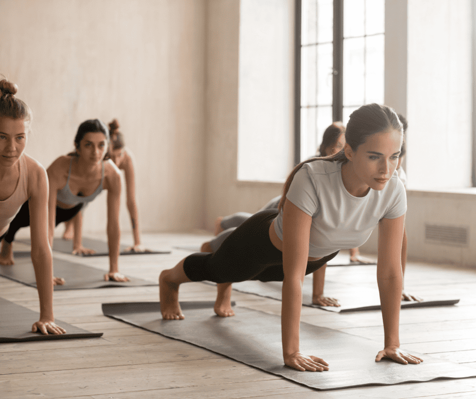 Group of women in exercise class holding plank position 
