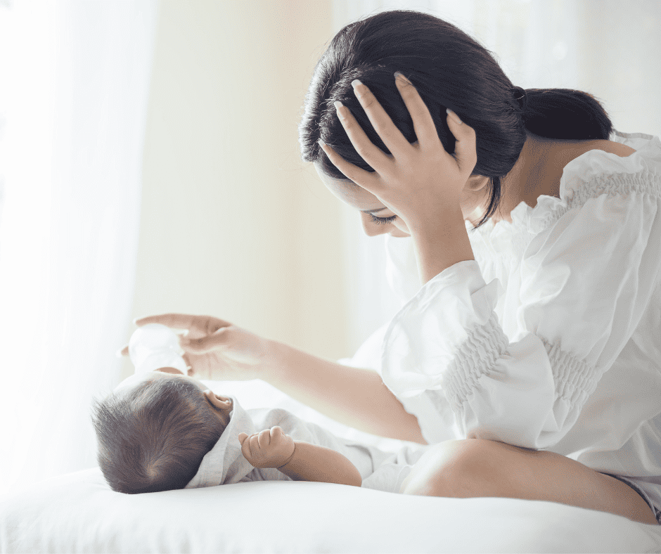 Baby laying down with woman bottle feeding them