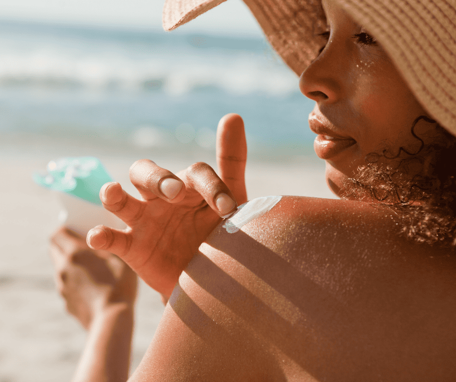 Woman putting sunscreen on her shoulder