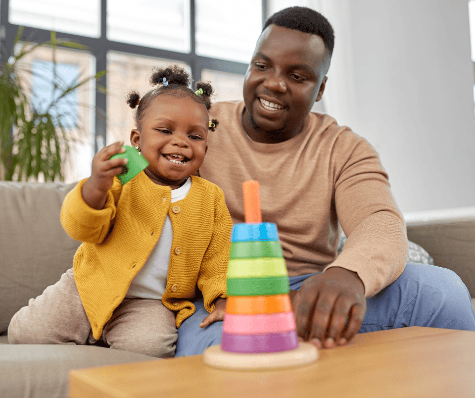 Father and child playing with stacking colorful rings