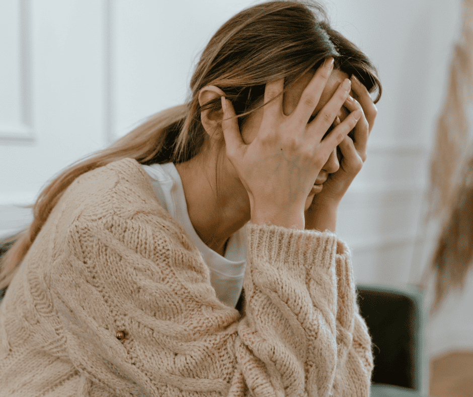 How stress affects pregnancy Woman holding her head in her hands