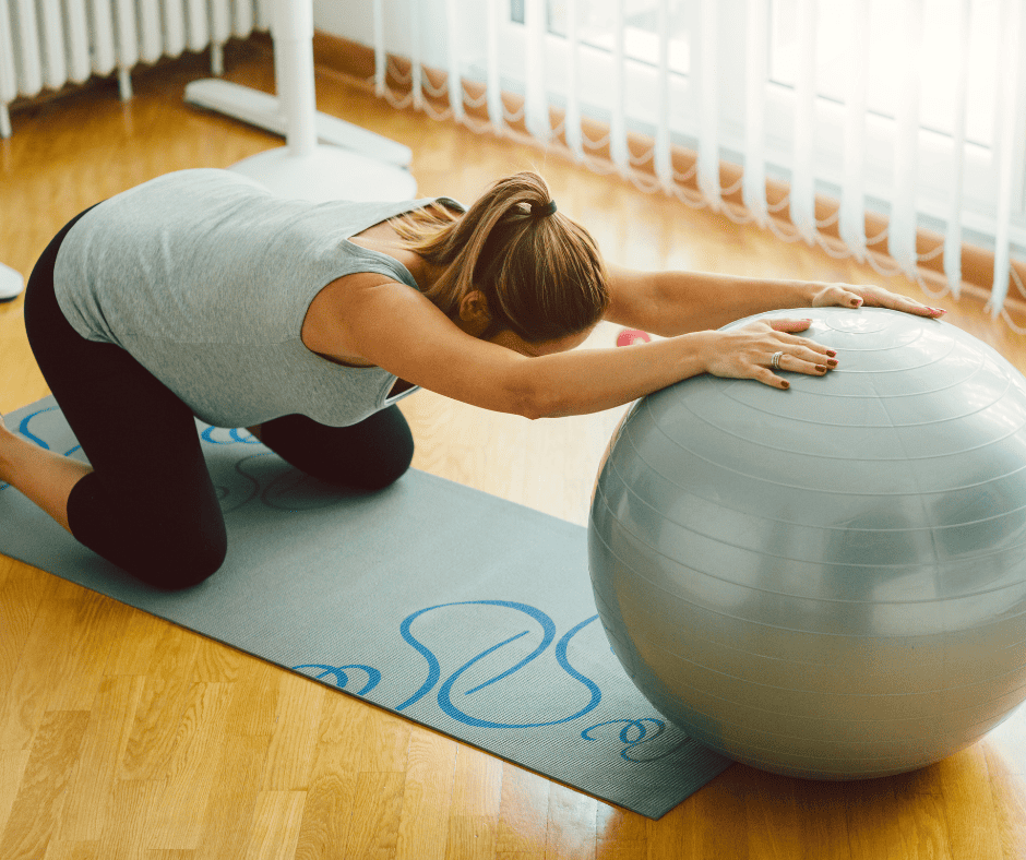 How stress affects pregnancy Pregnant woman stretching back on shoulders with exercise ball