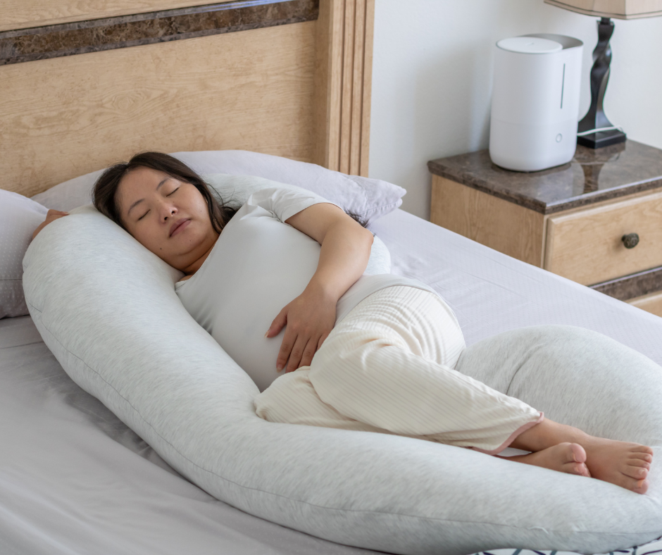 Pregnant woman sleeping with a pregnancy pillow