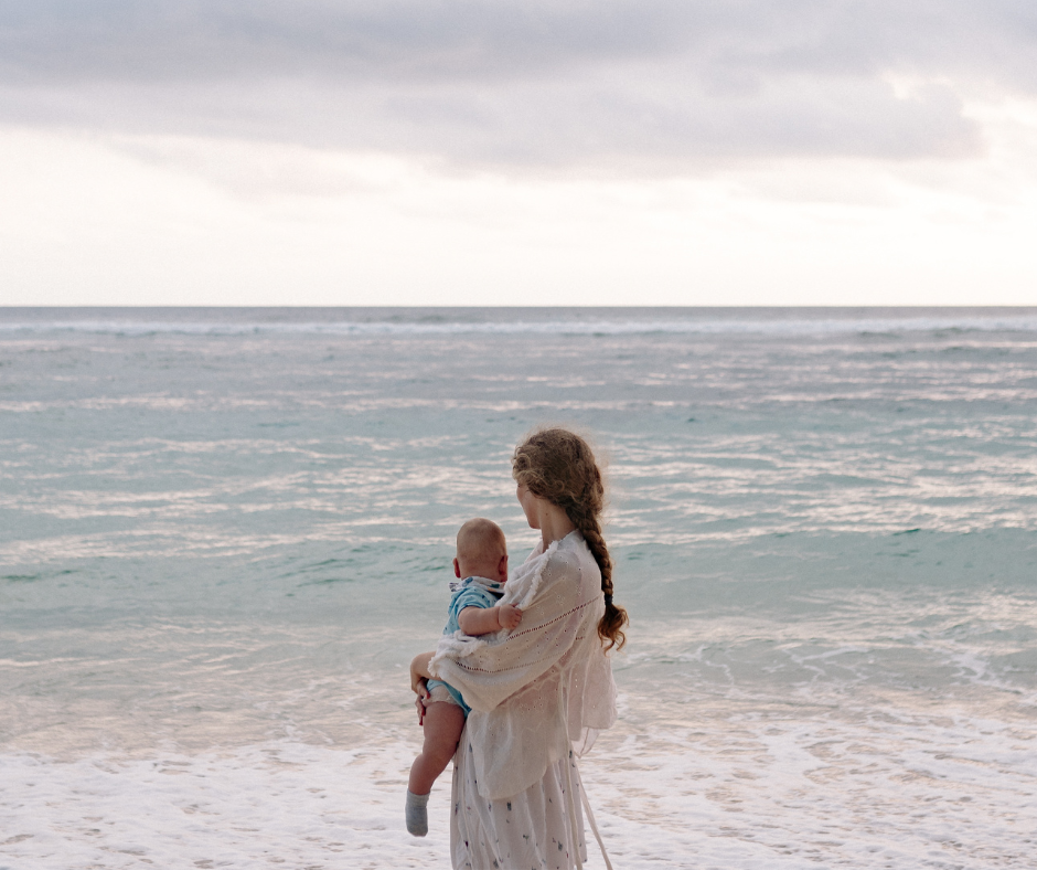 Woman holding baby on the beach